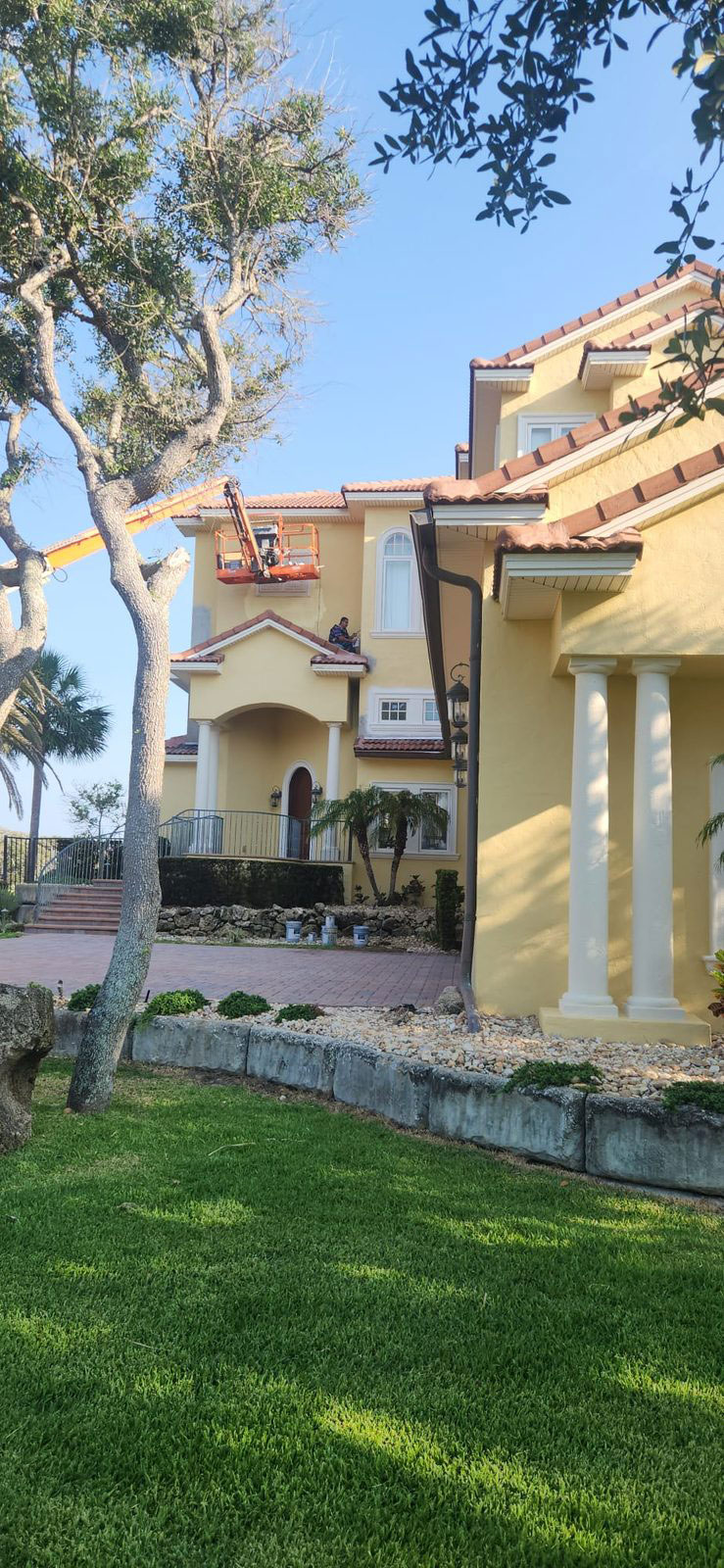 Finished exterior painting on the columned entry of a Mediterranean-style home
