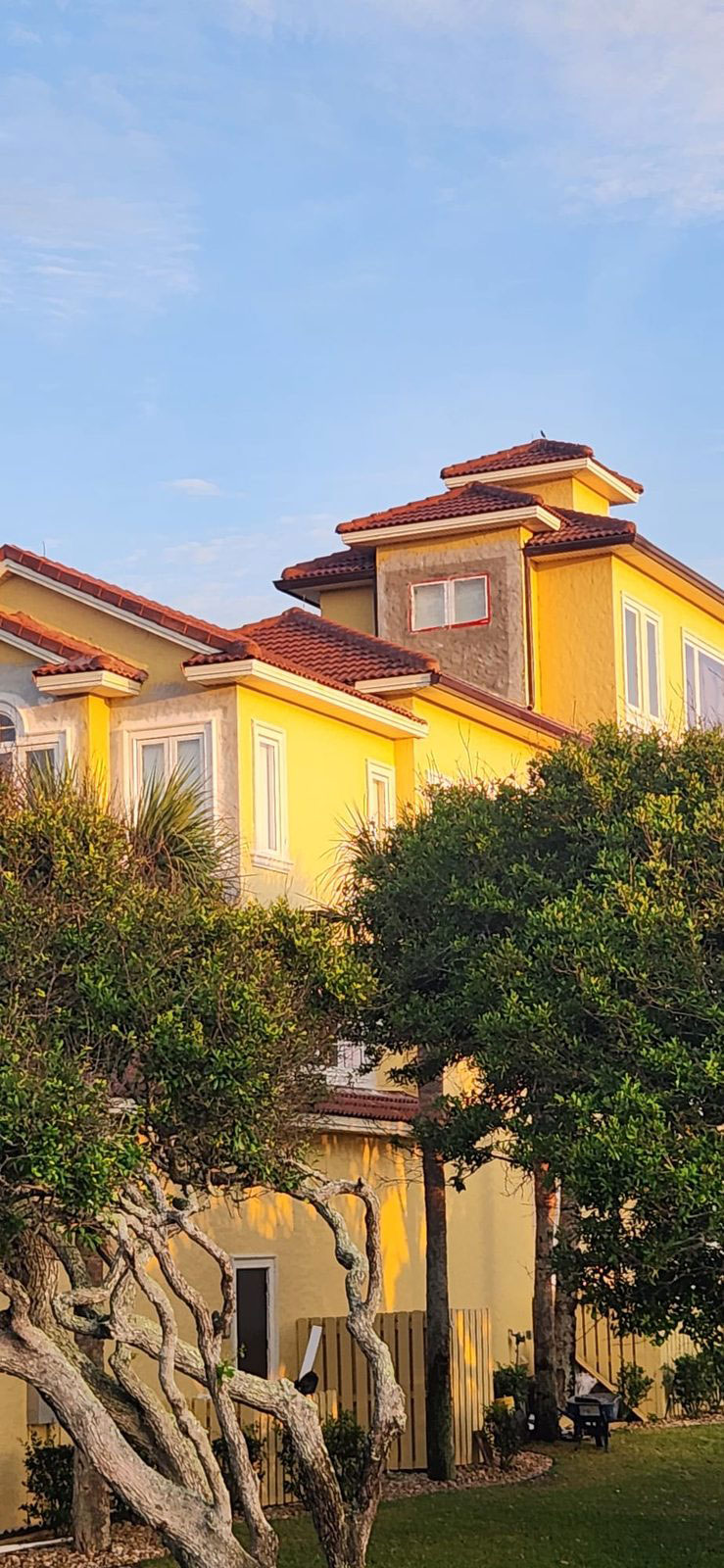 Yellow home at sunset with a stucco patch on the tower wall ready for paint