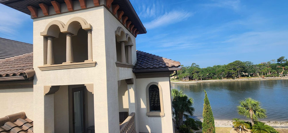 Tower with arched openings and tile roof on a waterfront home